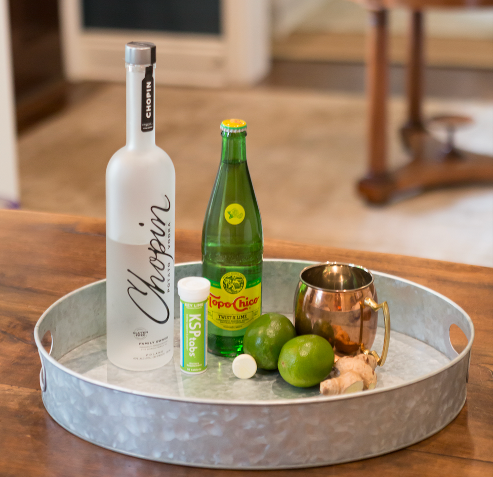 Moscow Mule cocktail ingredients with KSPtabs electrolytes — vodka, ginger beer, Topo Chico, lime, and copper mug